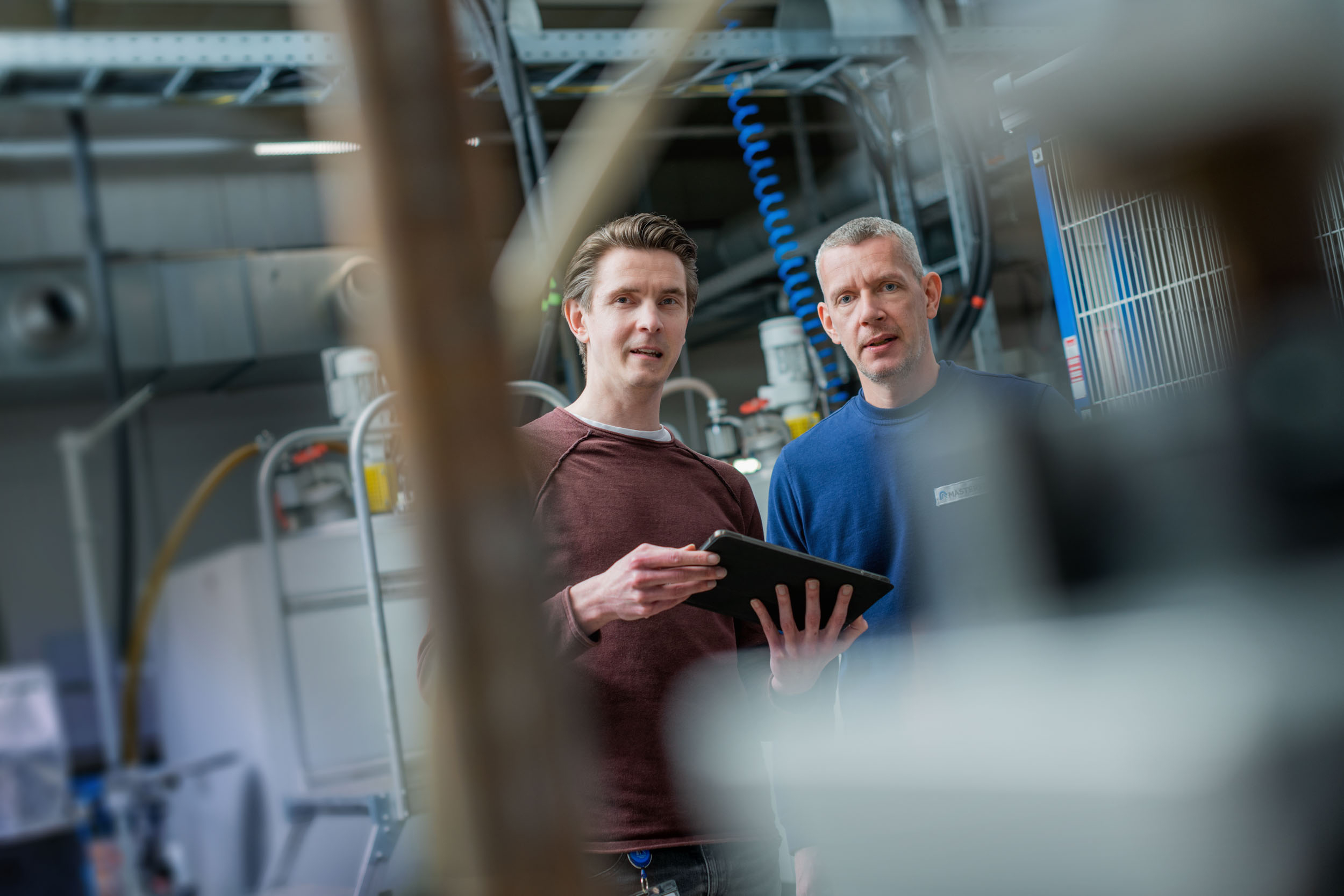 Masterduct: funcionários com ipad na unidade de produção de Gelsenkirchen Imagem de exemplo: Funcionários em pé com um ipad na unidade de produção de Gelsenkirchen